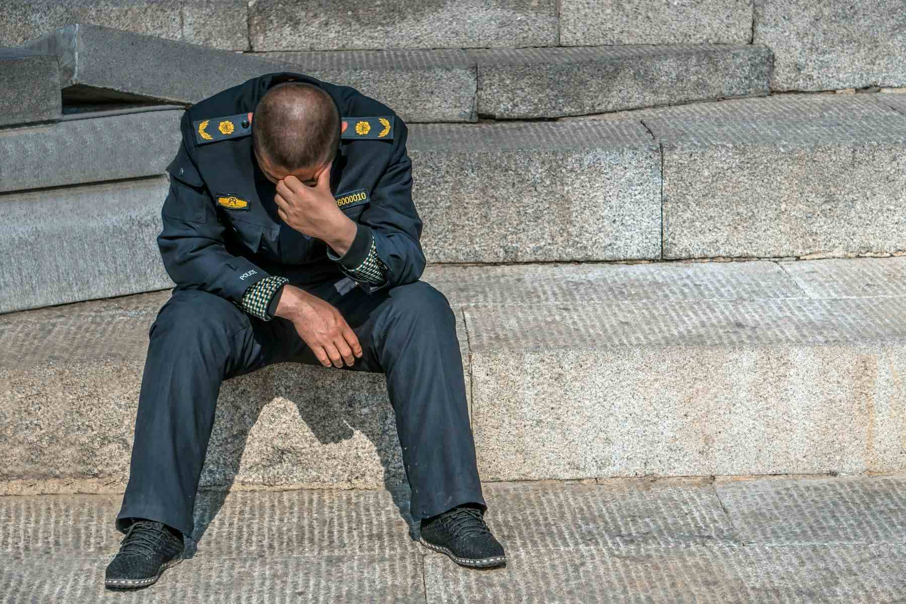 Police officer sitting with head down