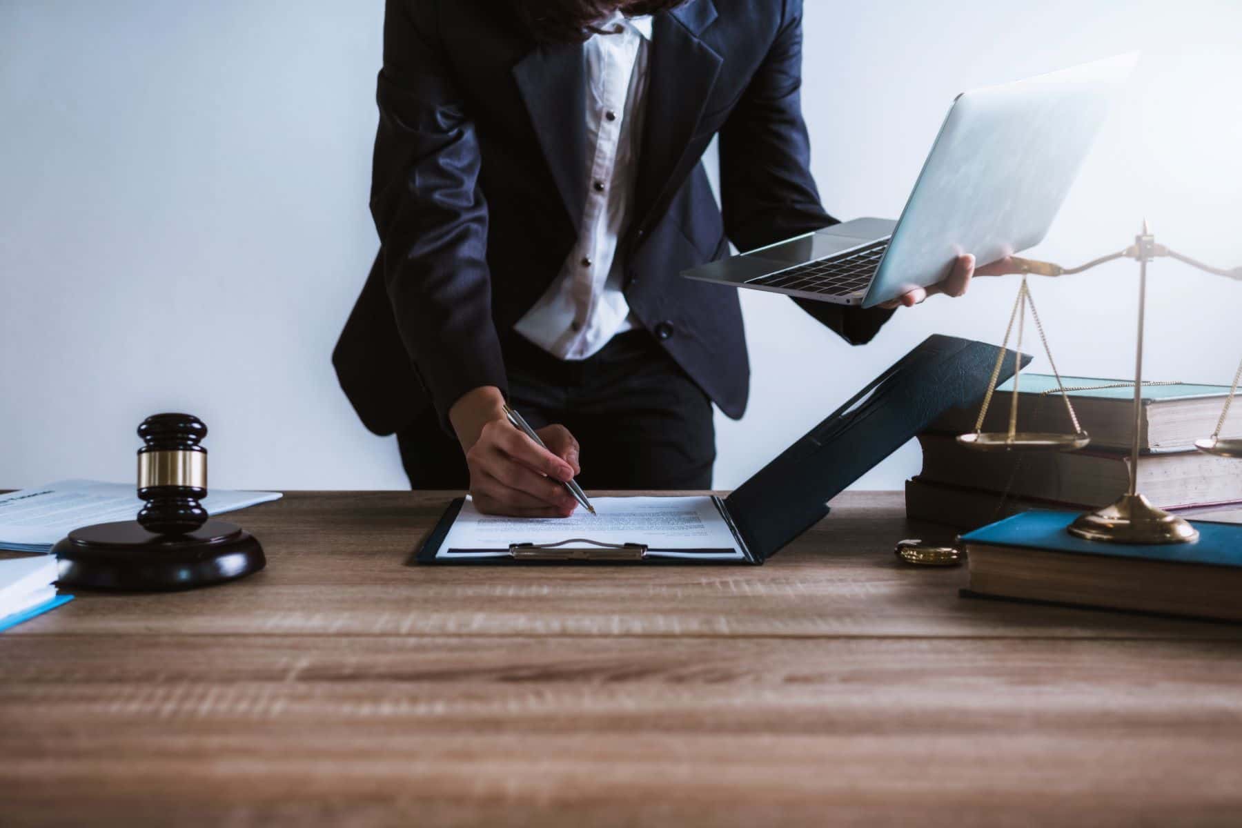 Attorney using laptop computer while writing