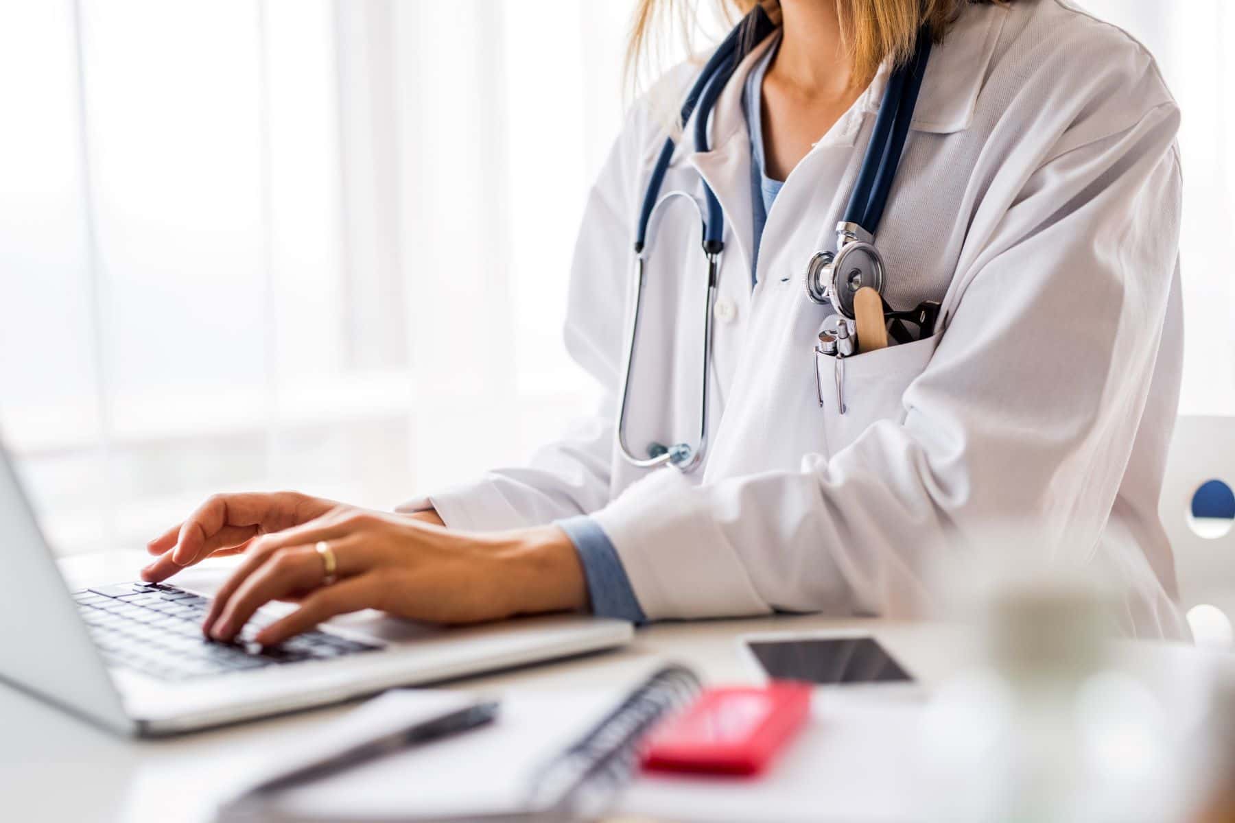 Doctor reviewing medical records on a laptop