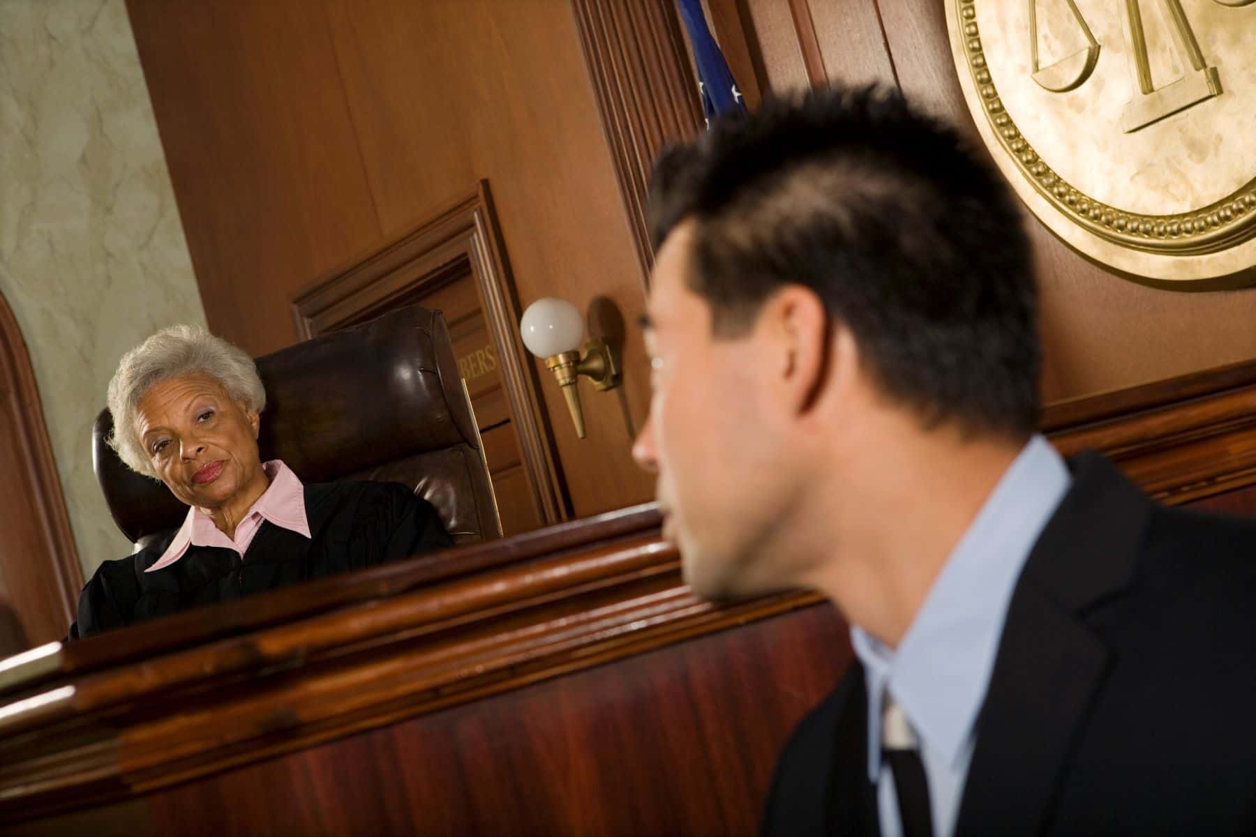 Senior judge and expert witness looking at each other in the courtroom