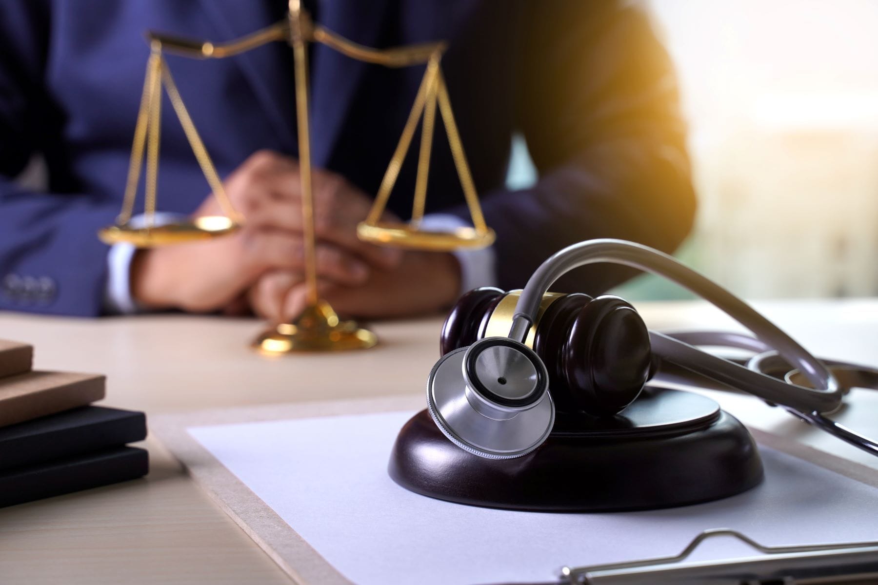 Gavel and stethoscope with attorney in background