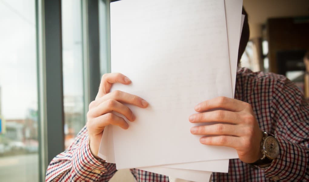 person holding up several papers
